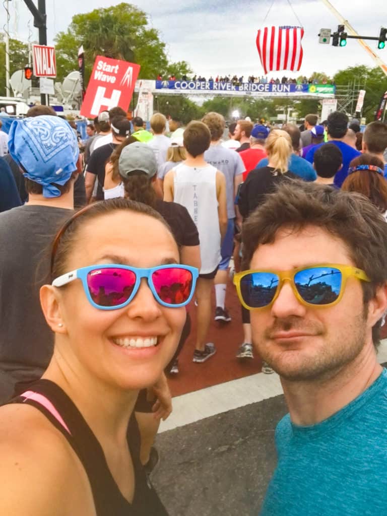 A male and female runner taking a selfie at the race start line at the Cooper River Bridge Run in Charleston, SC.