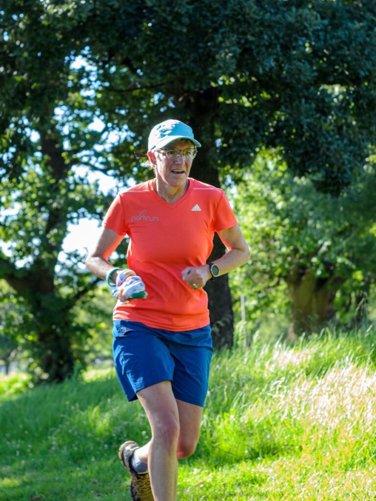 A runner runs outside on a sunny day.