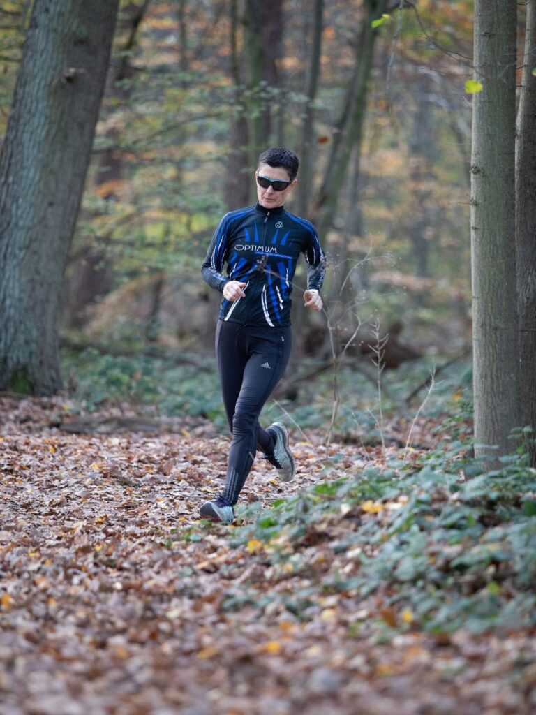 A person is running through a wooded area. 