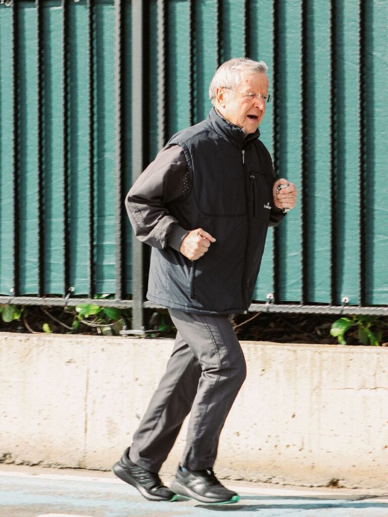 An older man is running. Age can determine how many steps are in a mile for an individual.