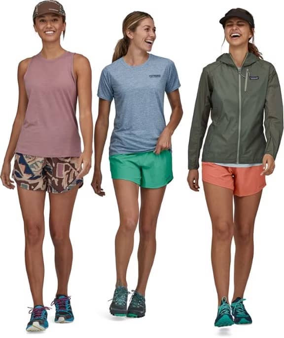 Three women are walking together wearing the Patagonia Trailfarer shorts in three different colors.